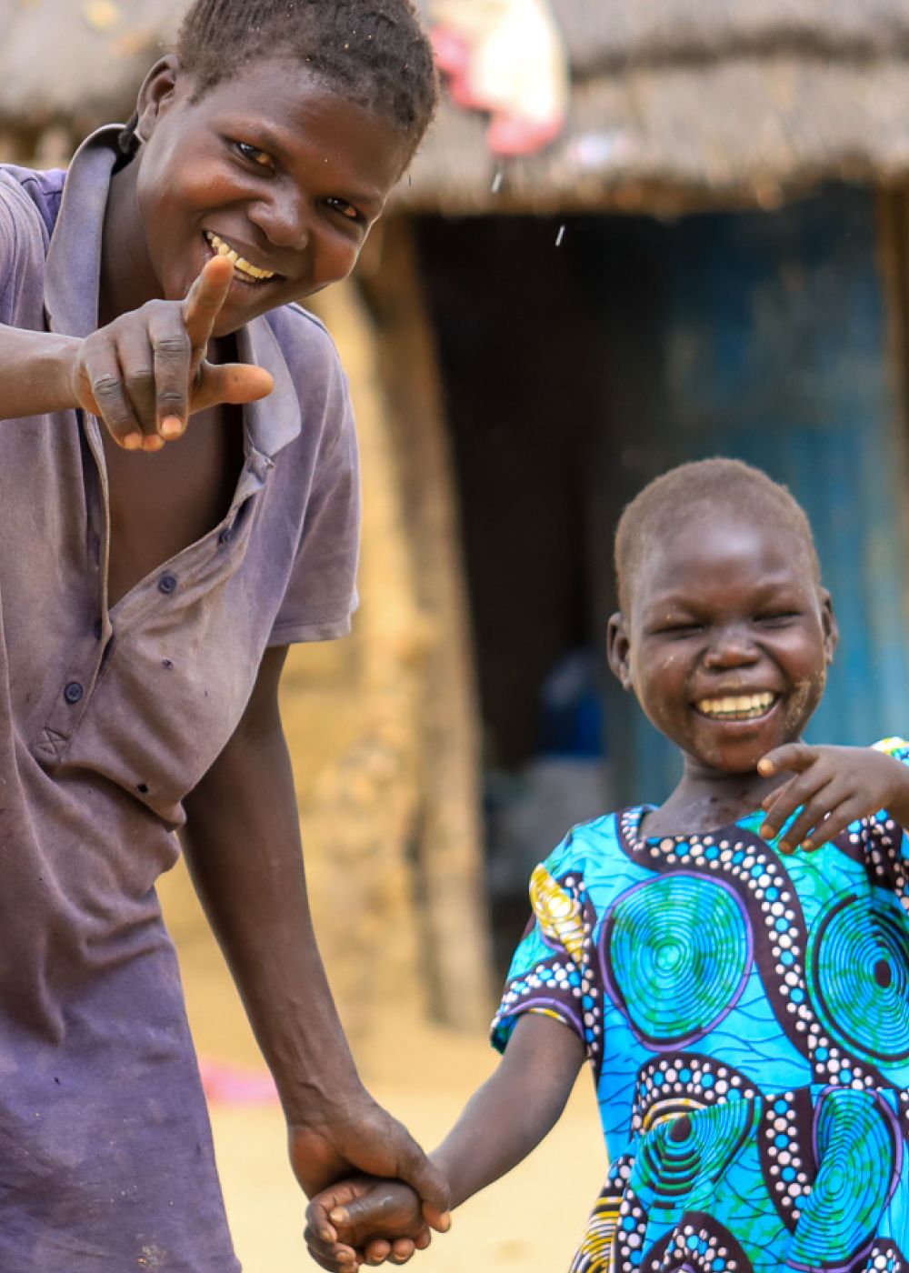 Woman and child smiling and pointing to the camera.