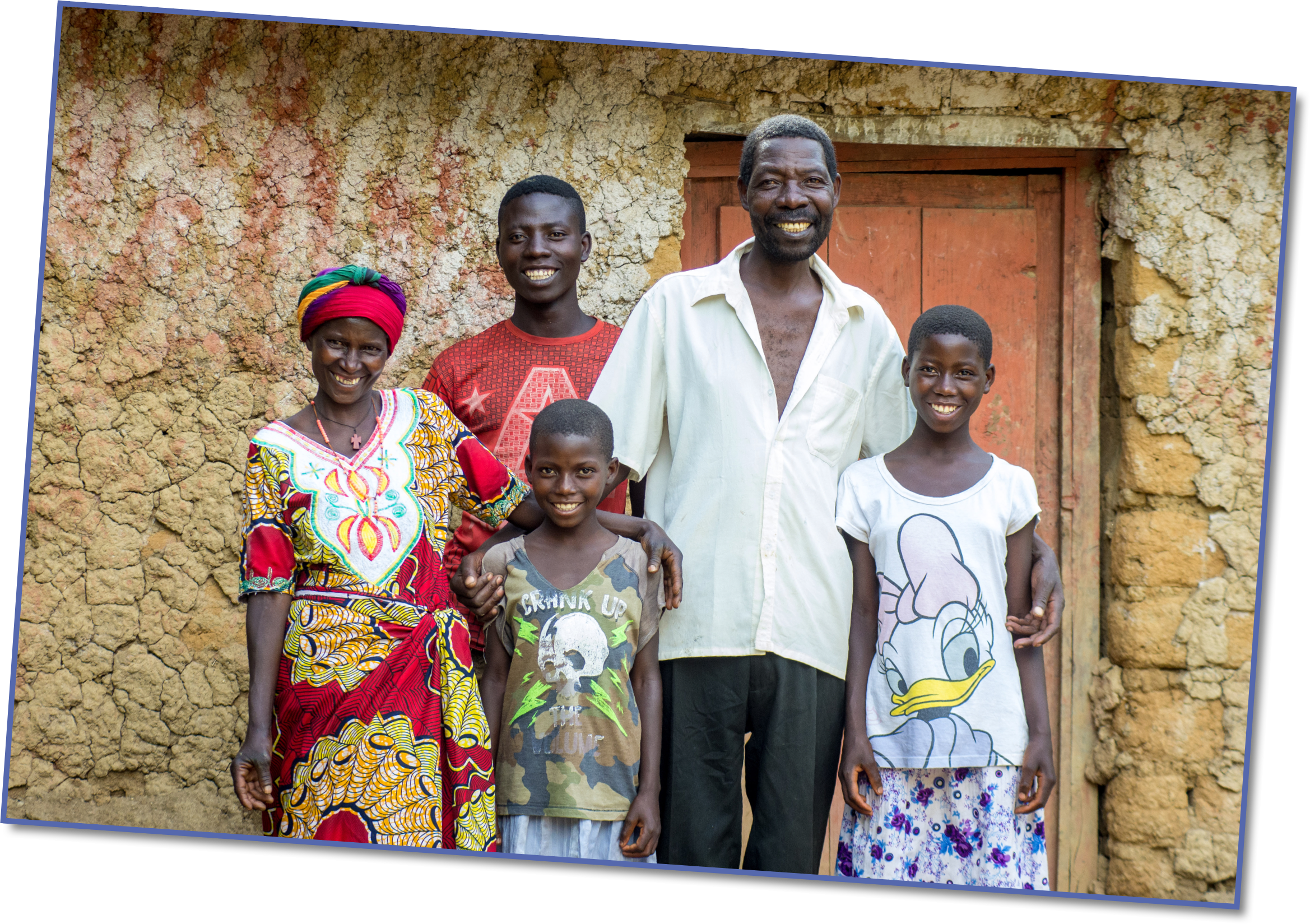 Scholastique, her husband and three of their children outside their old house, which left them wet when it rained