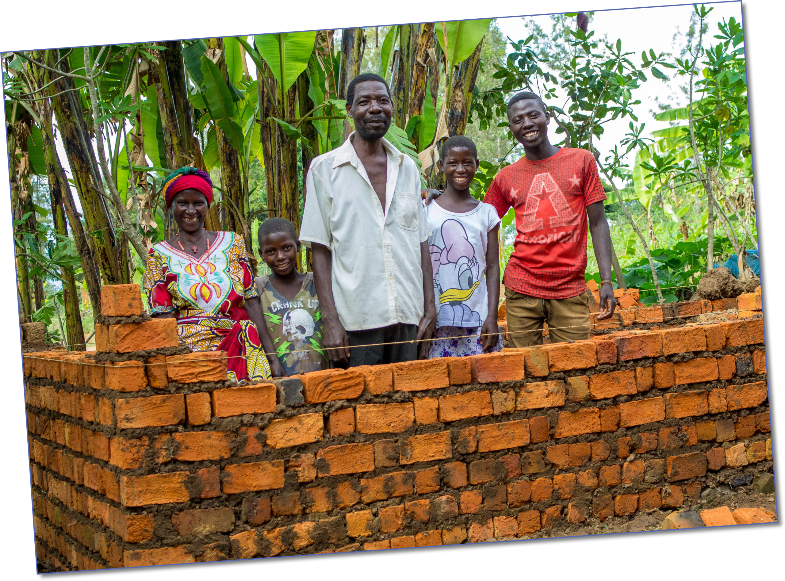 Scholastique, her husband and three of their children building their long-awaited brick house
